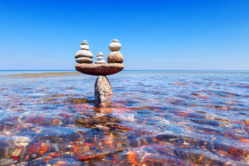 symbolic scales of standing stones in the water. The concept of balance.
