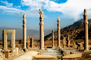 Persepolis is the capital of the ancient Achaemenid kingdom. Ancient columns. Sight of Iran. Ancient Persia. Blue sky and clouds background.
