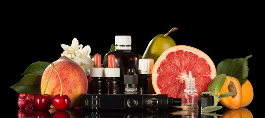 Electric cigarette, set of various liquids for smoking and fresh fruit isolated on black