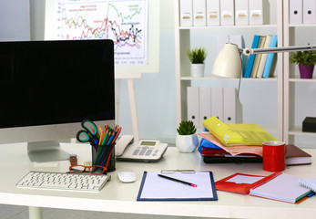 Office table with blank notepad and laptop