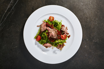 Roast beef with sun-dried tomatoes, green salad and fresh tomatoes
