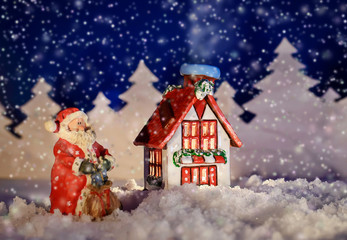 Christmas picture of a winter cottage and Santa