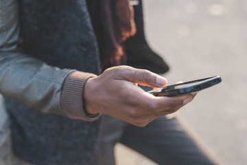 close up man hand holding and using smart phone - technology, social network, communication concept