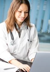 Cheerful female doctor with laptop