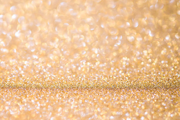 Gold Abstract Christmas twinkled bright background with bokeh defocused lights . Lights Festive background concept.