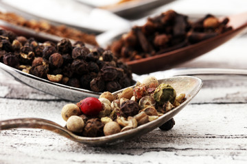 Various spices and spoons on white wooden table.