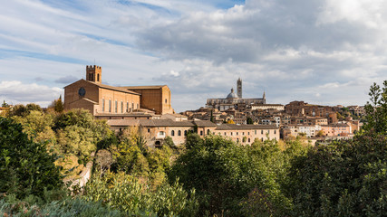 Fototapeta na wymiar Beautiful view of Dome and campanile of Siena Cathedral, Duomo di Siena, and Old Town of medieval city of Siena in the sunny day. Tuscany, Italy.
