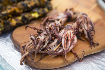 Grilled octopus on a wooden board at a street market