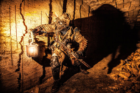 Underground post apocalyptic creature with homemade weapons and lantern