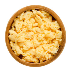 Scrambled eggs in wooden bowl. Yolk and white are stirred or beaten together, then cooked and ready to eat, a simple meal. Isolated macro food photo close up from above on white background.