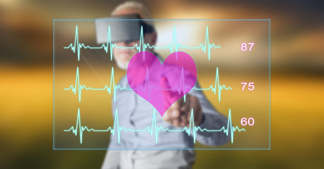 Man wearing a reality virtual headset touching a heart beats graph concept on a touch screen