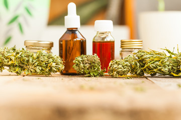 alternative medicine green leaves of medicinal cannabis with extract oil on a wooden table
