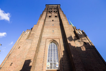 Fototapeta na wymiar The bell tower of St. Mary's Church (Bazylika Mariacka), a Roman Catholic church in Gdansk, Poland, and one of the largest brick churches in the world