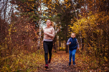 Fototapeta premium Little boy and his sister running in autumn forest