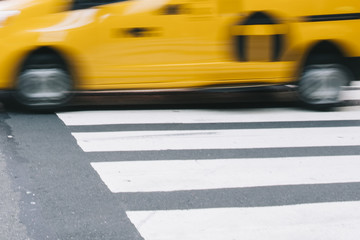 Abstract blur of urban street scene with a yellow taxi cab in New York, United States