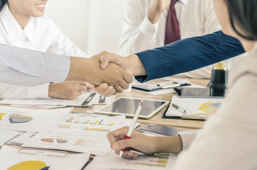 Businessman shaking hands to seal a deal with his partner and colleagues after finishing up meetingin a modern office