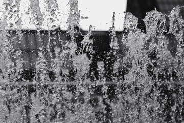 Close-up of a splash of water in a fountain. Black and white photography.