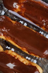 Delicious eclairs with chocolate frosting on the table 
