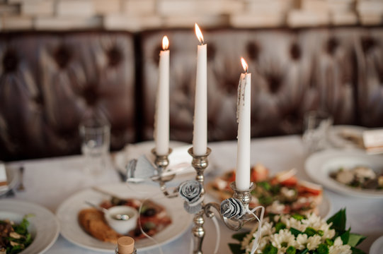 Three candles in the elegant candle holder decorating a table