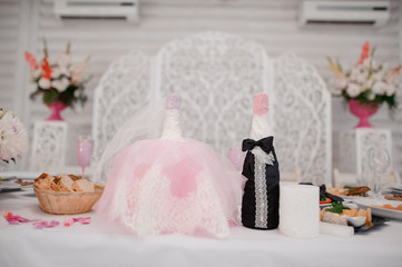 Fototapeta na wymiar Cute champagne bottles decorated in newlyweds clothes