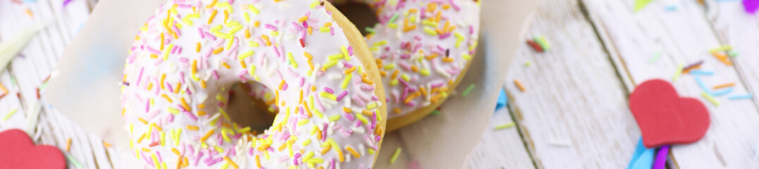 Horizontal bakground of donuts on a wooden