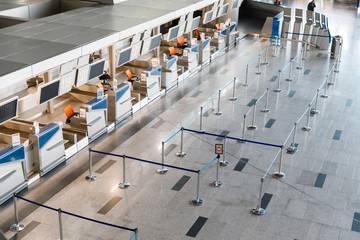 Empty check-in desks with computers and waiting lines in front in airport