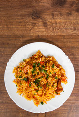 Rice with Vegetables and Meat in a plate on wooden table. with copy space. top view