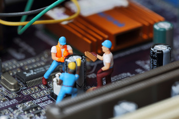 Selective focus of miniature engineer and worker fixed to remove chip and  mainboard computer and use for business background.