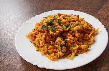Rice with Vegetables and Meat in a plate on wooden table.