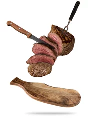 Tuinposter Flying beef steaks served on wooden cutting board © Jag_cz