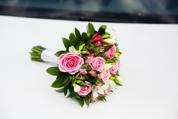 Beautiful bridal bouquet on the car hood
