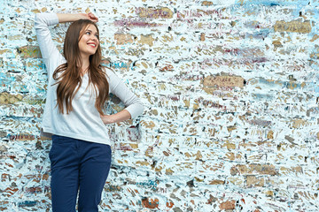 woman with long hair posing on grunge brick wall background.