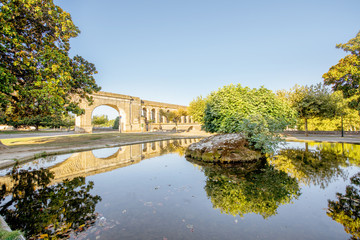 Naklejka premium View on the saint Clement aqueduct in Peyrou garden with water reflection during the morning light in Montpellier city in southern France