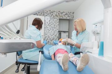 Little girl sitting in the dentists office