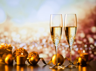 two champagne glasses against holiday lights and fireworks - new year celebration