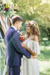 Wedding ceremony at outdoor park - bride and groom touching each other.