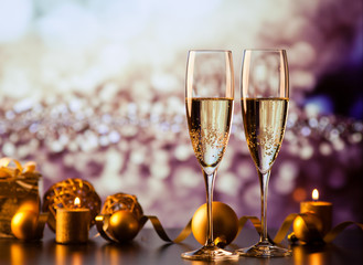 two champagne glasses against holiday lights and fireworks - new year celebration