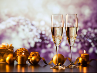 two champagne glasses against holiday lights and fireworks - new year celebration