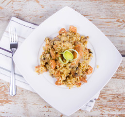 Risotto with mushrooms and chicken decorated with leek on a wooden background 