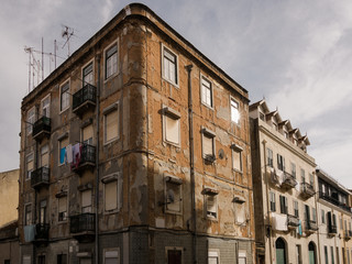 Fototapeta na wymiar Dilapidated worn classic apartment building facade in city street