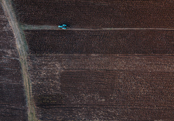 Aerial view of a farmer driving a tractor plowing and prepairing soil for the winter