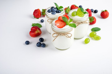 Fresh yogurt with berries in glass jars. Dairy products. Healthy food, dieting and breakfast concept. Copy space