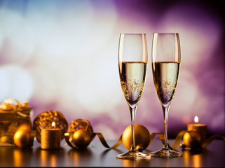 two champagne glasses against holiday lights and fireworks - new year celebration