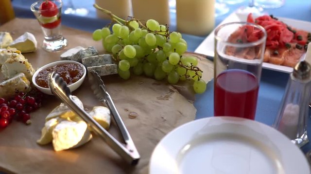 Brie, camambert, gauda, grapes and currants on a wooden background.