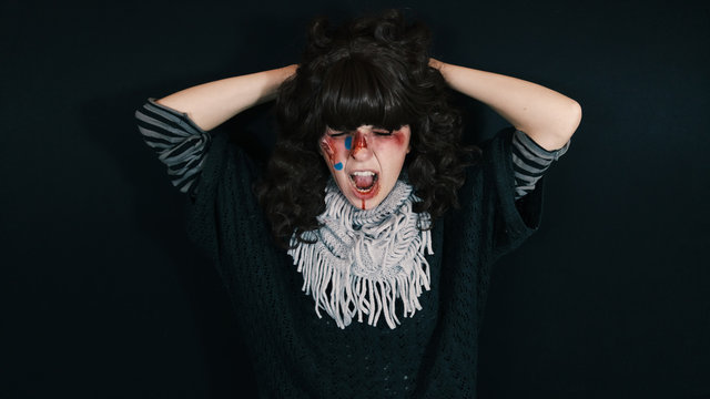 Chica joven asustada con heridas y sangre en la cara 