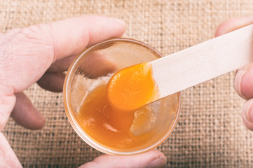 Hand holding a glass of orange jelly made of Psyllium mucilage