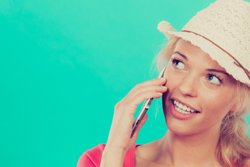 Tourist woman with sun hat talking on phone