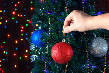 Man decorates the Christmas tree balls