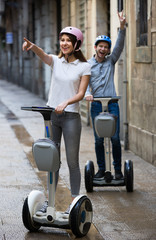 Young couple driving segways .