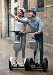 Happy couple going sightseeing by segways